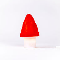 Mushroom-shaped lamp with red cap and white base on a white background